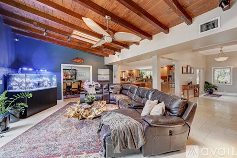 A living room with a brown leather couch and a rug.