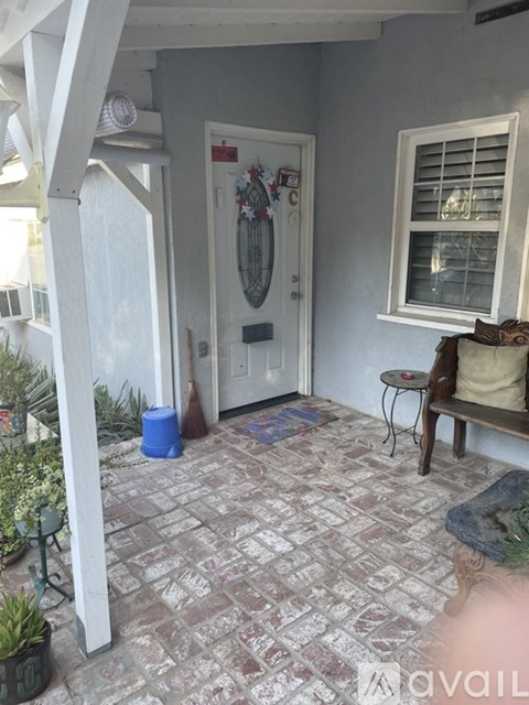 A patio with a door and a table with a chair.