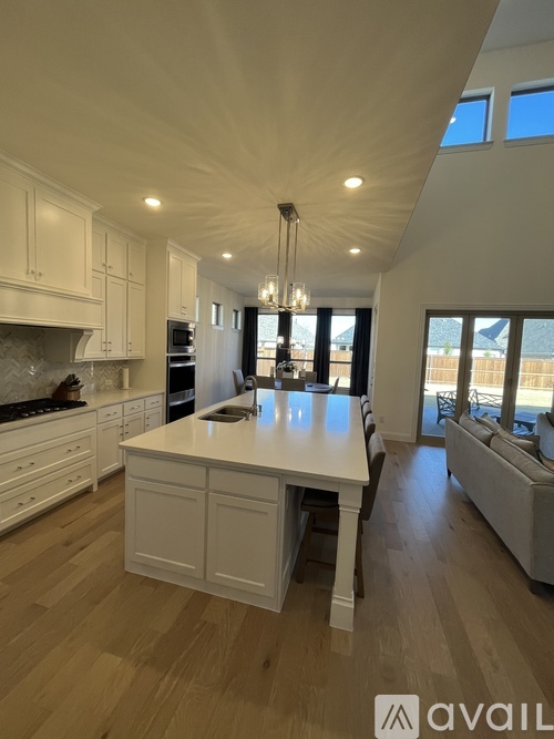 A modern kitchen with white cabinets and a large island.