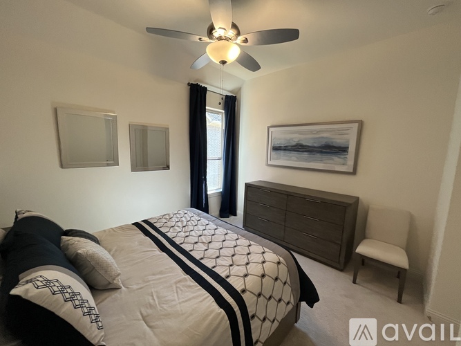 A bedroom with a large bed and a ceiling fan.