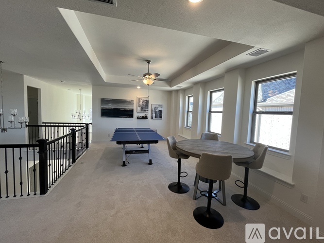 A spacious room with a table, chairs, and a ping pong table.