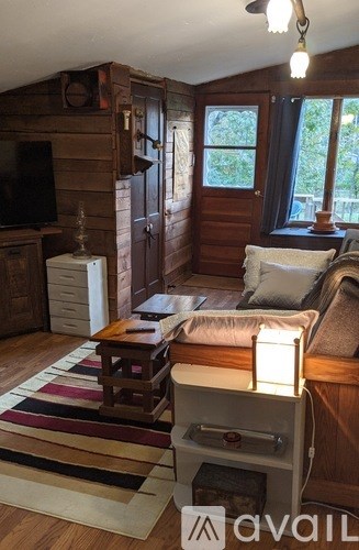 A living room with a couch, a coffee table, and a television.