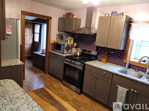 A kitchen with a black stove top oven and a black refrigerator.