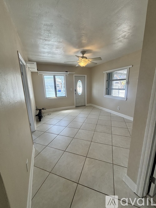 A room with a ceiling fan and tile flooring.