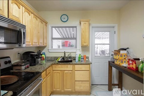 A kitchen with wooden cabinets and a white door.