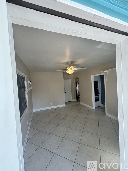 A room with a ceiling fan and tiled flooring.