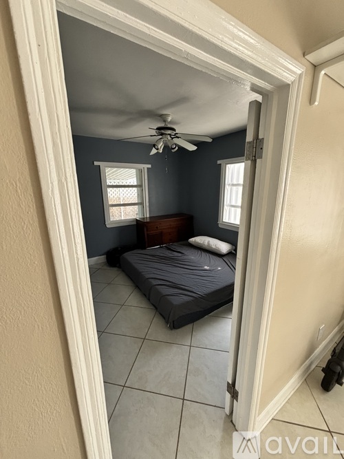 A bedroom with a bed and a ceiling fan.