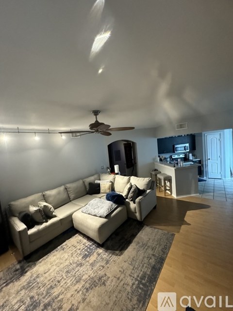 A living room with a white couch and a ceiling fan.