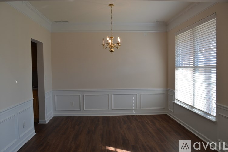 A room with wooden floors and a chandelier hanging from the ceiling.
