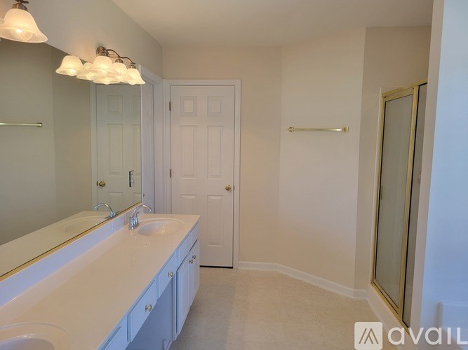 A bathroom with a sink, mirror, and a door.