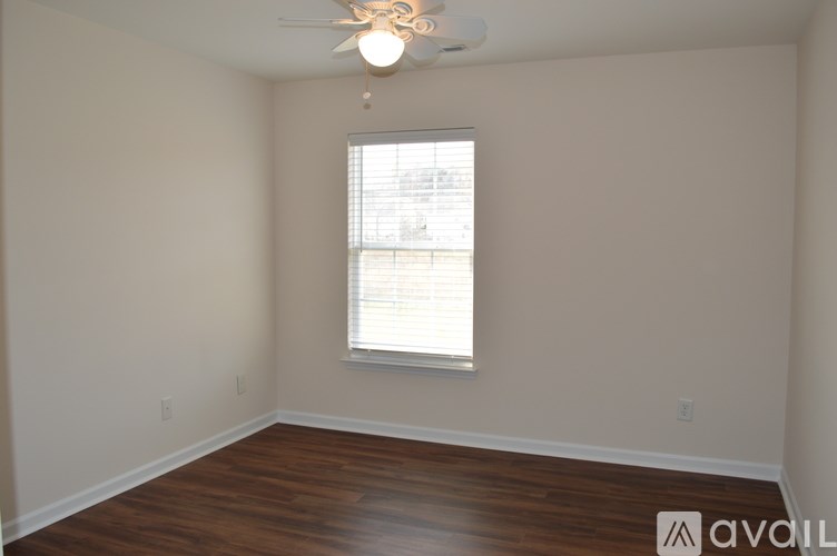 A room with a window and wooden flooring.