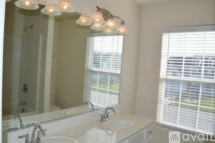 A bathroom with a white sink and a large mirror.