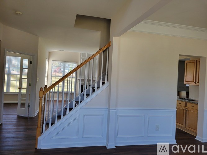 A staircase with white railings and a wooden handrail leads to a second floor.