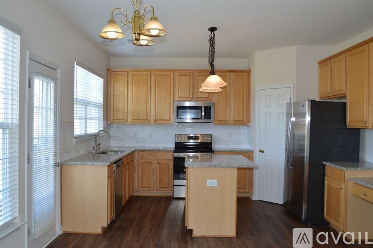 A kitchen with wooden cabinets and a black refrigerator.