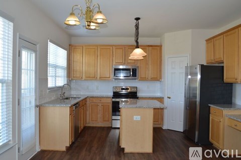 A kitchen with wooden cabinets and a black refrigerator.