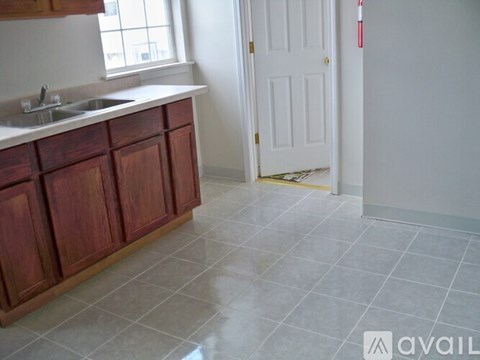 A kitchen with wooden cabinets and a white door.