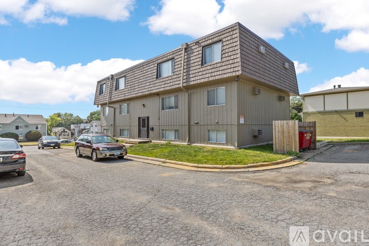 A modern house with a brown roof and a parking lot in front.