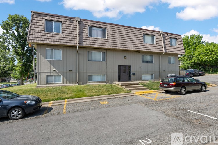 A two-story apartment building with a parking lot in front.