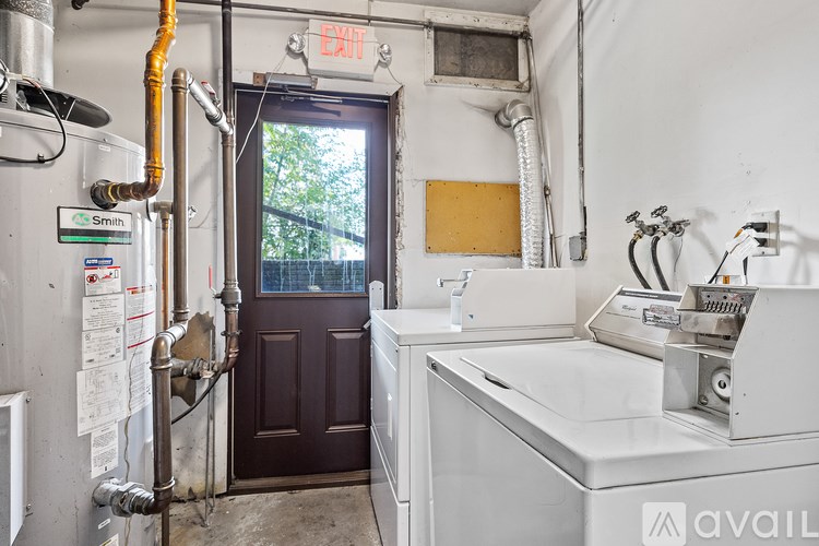 A dirty industrial room with a sink and a door.