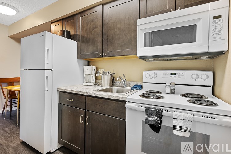 A kitchen with a white refrigerator, white stove, and a white microwave.