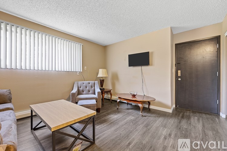 A living room with a wooden table and a grey sofa.