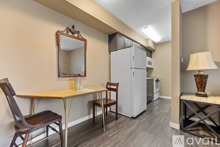 A room with a table, chairs and a fridge.