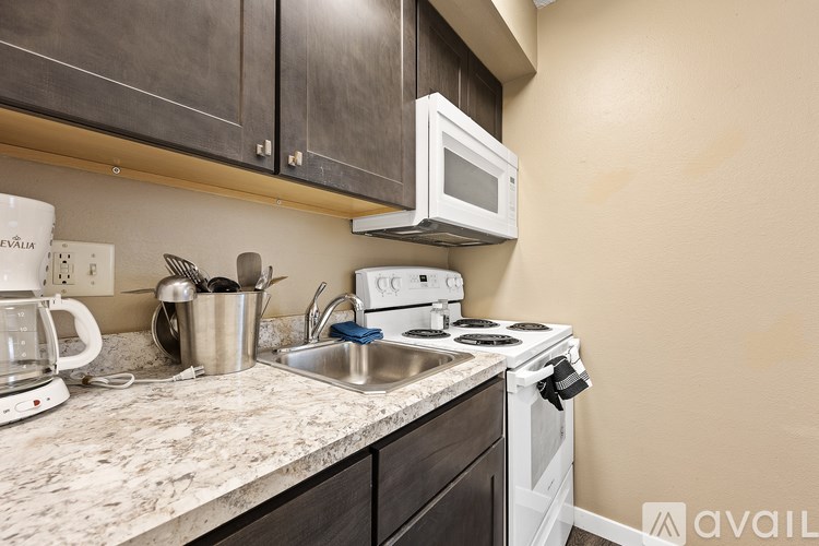 A kitchen with a white stove top oven and a white microwave above it.