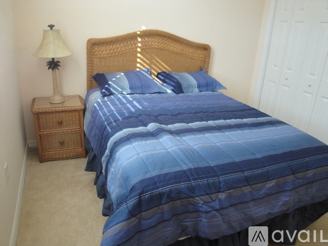 A bed with a brown comforter and a metal frame.