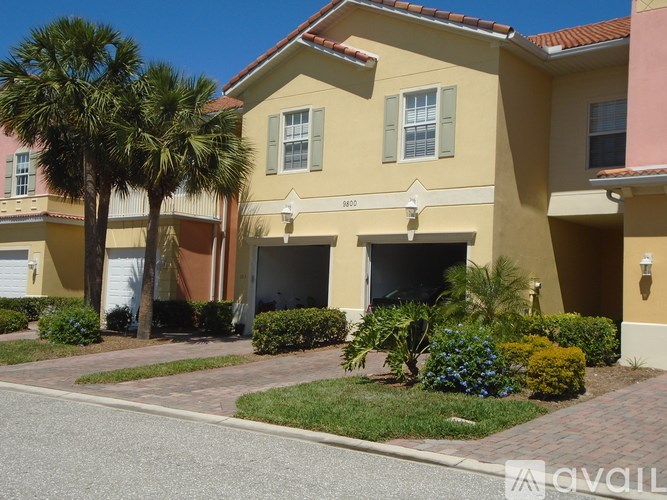 A yellow house with a red roof and a white garage door.