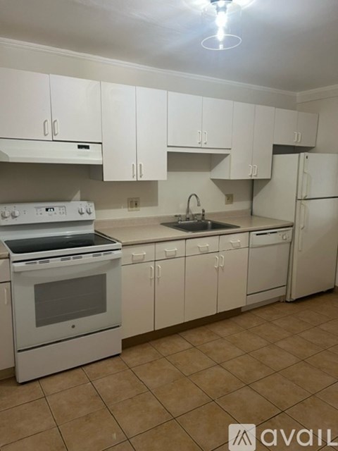 A kitchen with white cabinets and appliances.