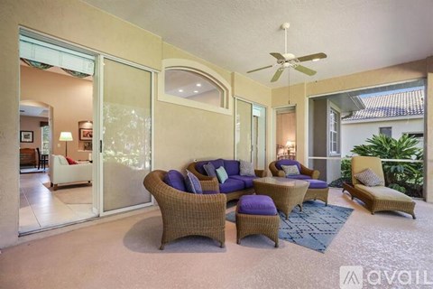A living room with a sofa set and a ceiling fan.