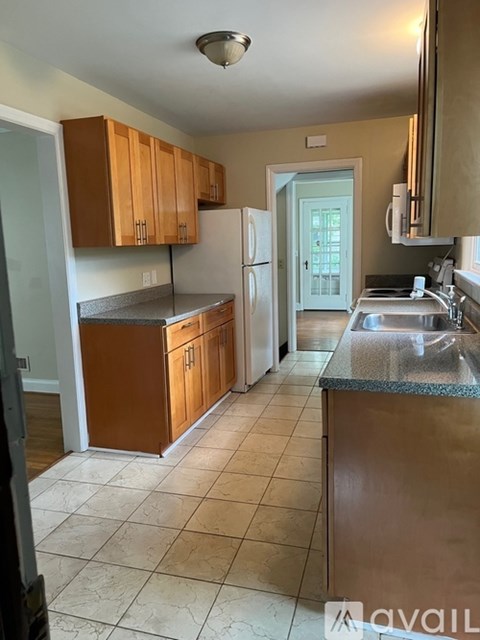 A kitchen with brown cabinets and a white refrigerator.