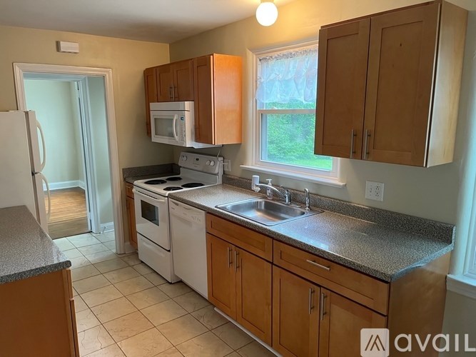 A kitchen with wooden cabinets and a granite countertop.