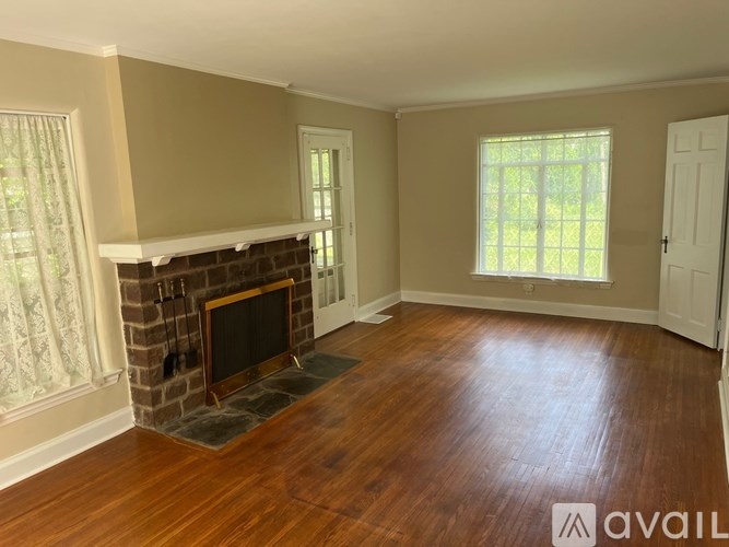 A living room with a fireplace and wooden floors.