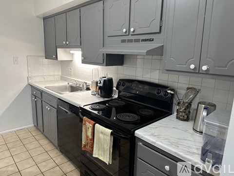 A kitchen with a black stove top oven and a white counter top.