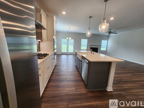 A modern kitchen with dark wood floors and white cabinetry.