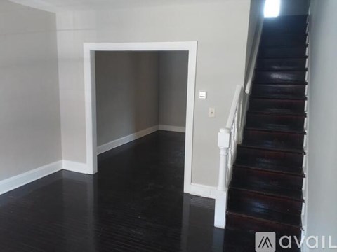A hallway with a staircase and a doorway.