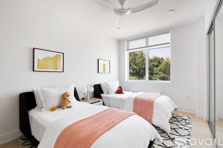 A bedroom with two beds and a ceiling fan.
