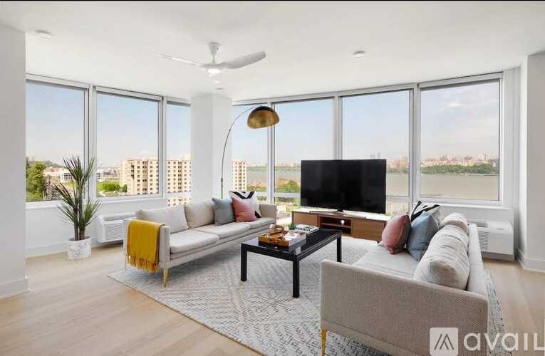 A living room with a grey couch, a black coffee table, and a flat screen TV.