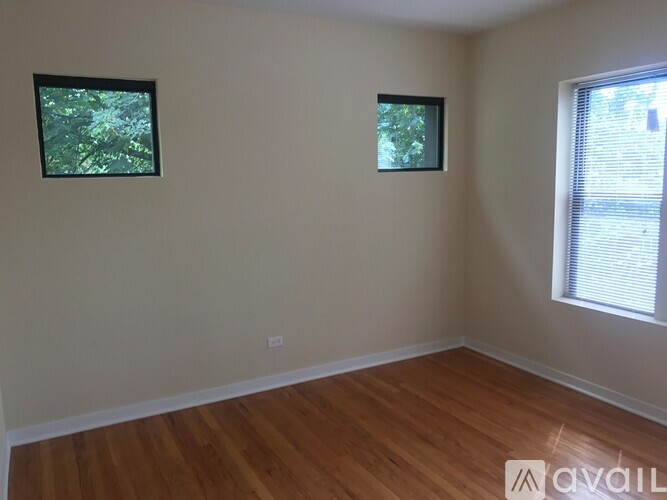 A room with wooden floors and two windows.