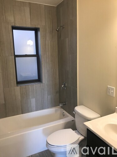 A bathroom with a tub, toilet, and sink.