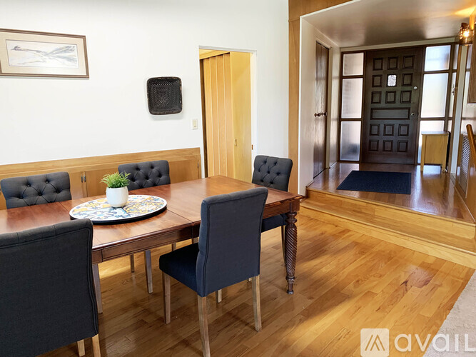 A dining room with a wooden table and chairs.