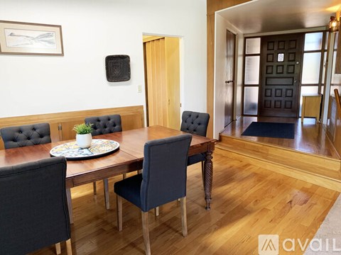 A dining room with a wooden table and chairs.