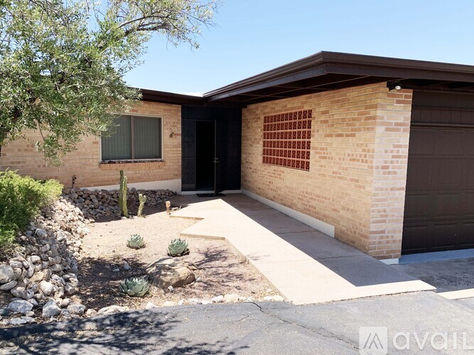 A house with a brown brick exterior and a black door is for sale.