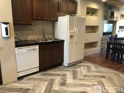 A kitchen with a white refrigerator and a black dishwasher.