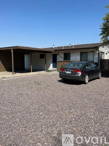 A car is parked in front of a building with a sign that reads "Avail".