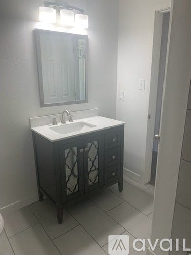 A bathroom vanity with a mirror and lights above it.