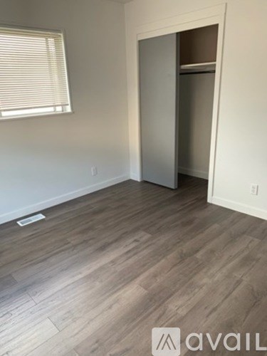 A room with a wooden floor and a white door.