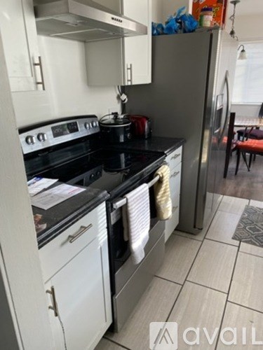 A kitchen with a black stove top oven and white cabinets.