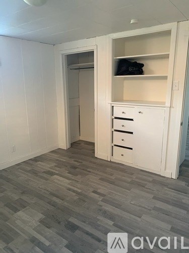A room with a white closet and drawers.